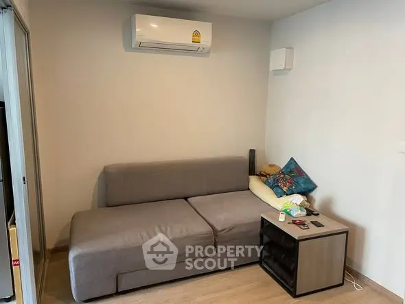 Cozy living room with modern gray sofa and air conditioning unit