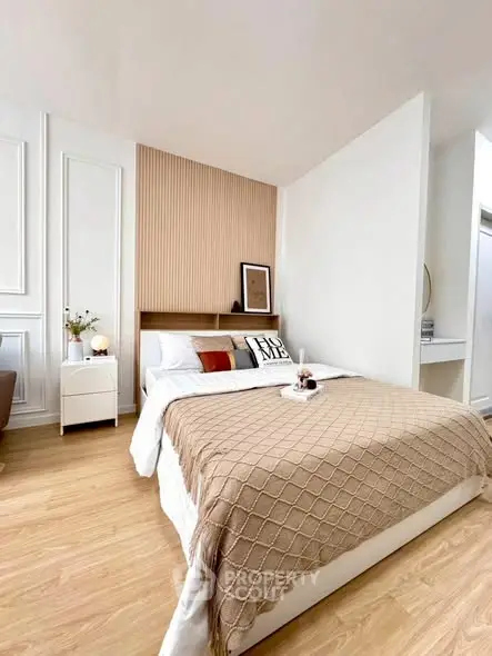 Stylish modern bedroom with cozy decor and elegant wooden flooring.