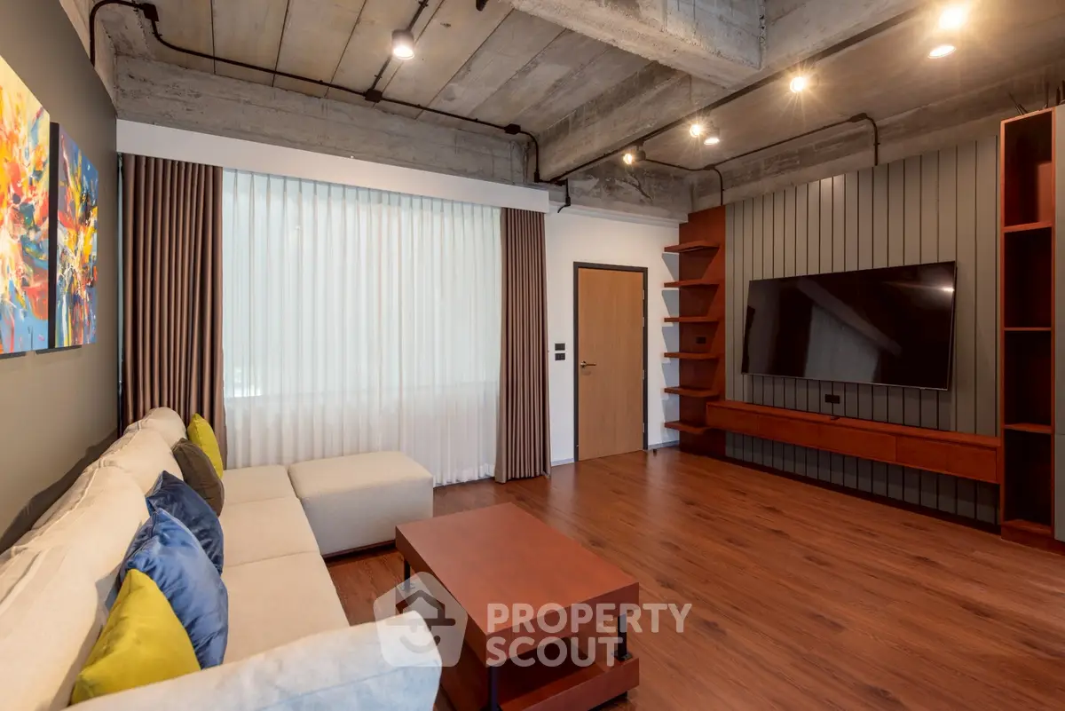 Modern living room with stylish decor, large TV, and cozy seating area.