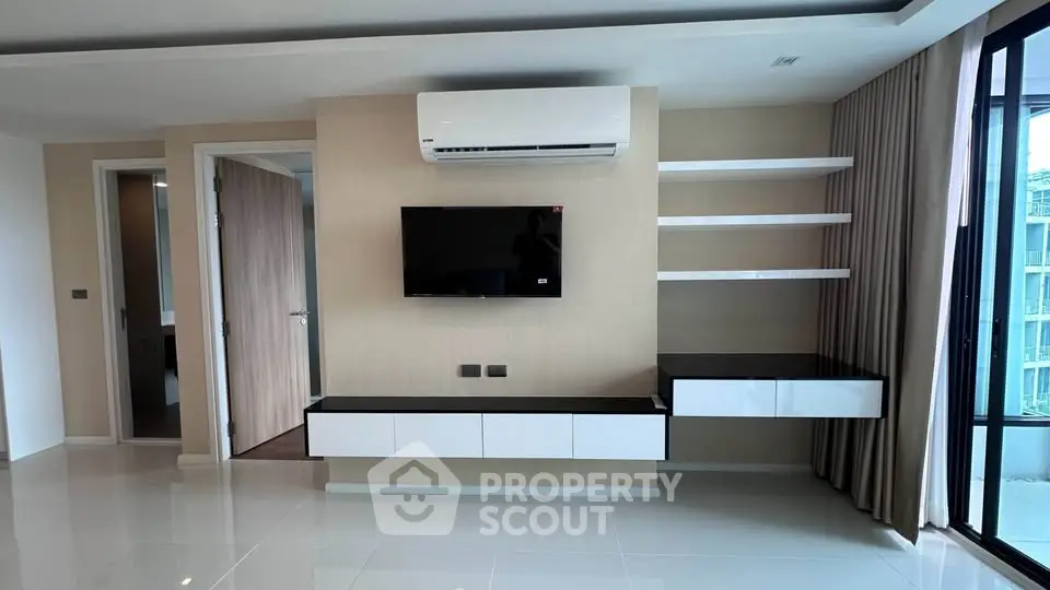 Modern living room with sleek TV unit and air conditioning, featuring open shelves and elegant design.