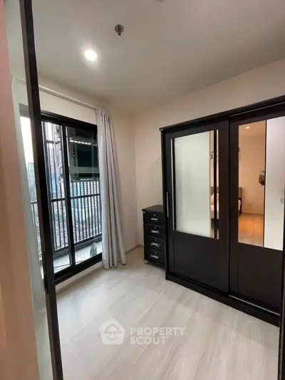 Modern bedroom with sleek wardrobe and balcony access in urban apartment
