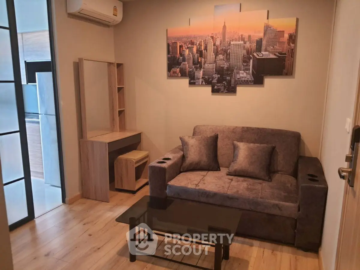 Cozy living room with modern decor and cityscape artwork, featuring a plush sofa and glass coffee table.