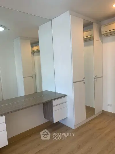 Modern bedroom with built-in wardrobe and sleek wooden flooring