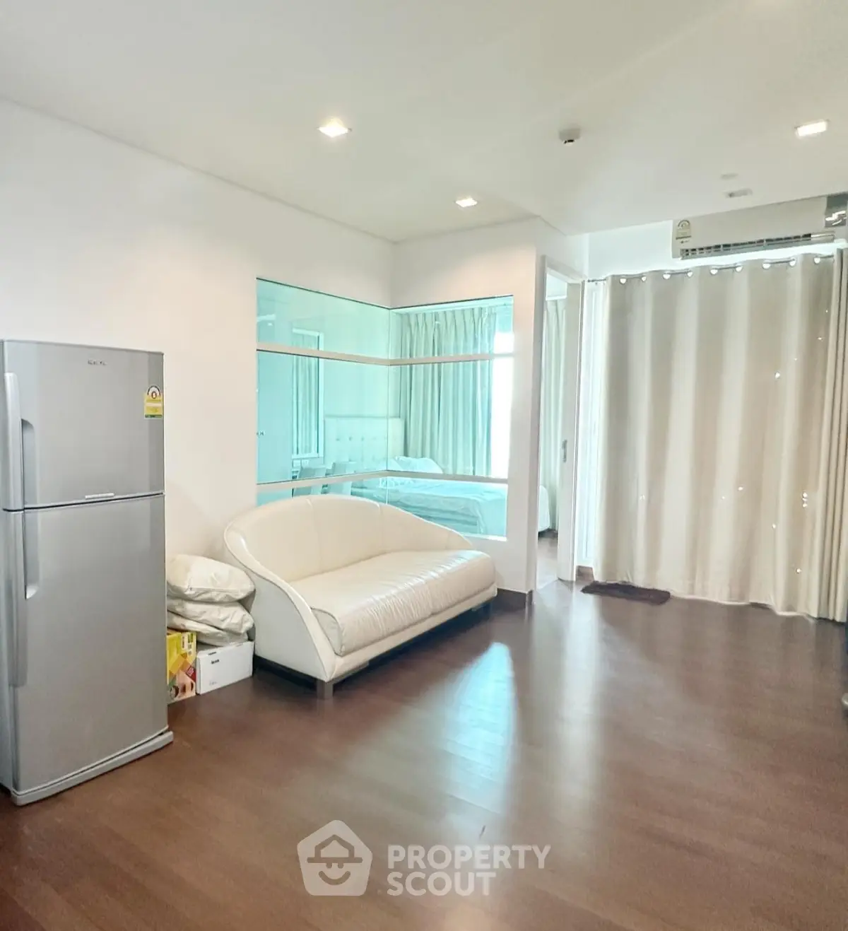Spacious living room with modern decor and large windows in a stylish apartment.