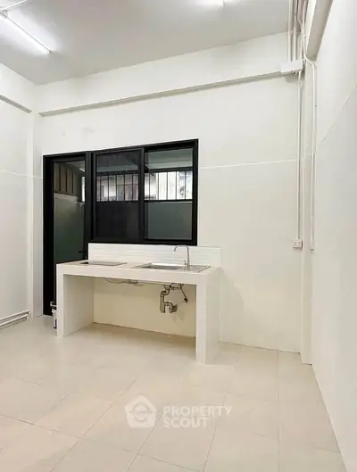 Minimalist kitchen with tiled countertop and sink in modern apartment