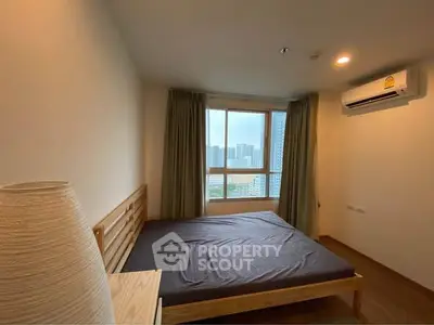 Cozy bedroom with city view, wooden bed frame, and air conditioning unit.