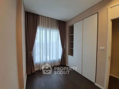 Spacious bedroom with elegant curtains and built-in closet, perfect for modern living.