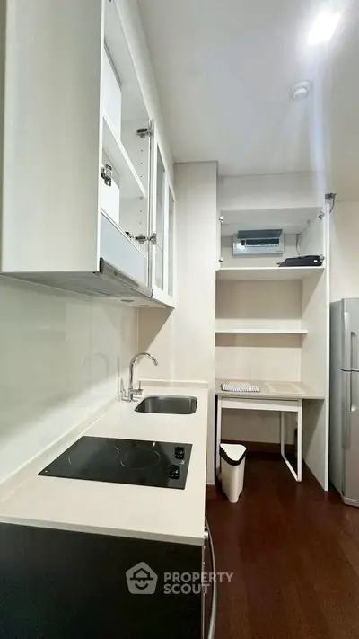 Modern kitchen with sleek white cabinetry and electric cooktop