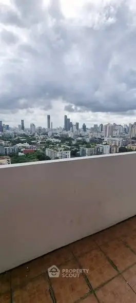 Stunning cityscape view from a high-rise balcony with overcast skies.