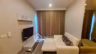 Cozy living room with modern sofa and wall-mounted TV, perfect for relaxation.