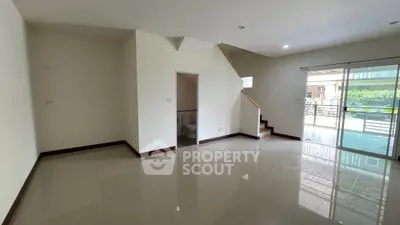 Spacious living area with glossy tile flooring and natural light