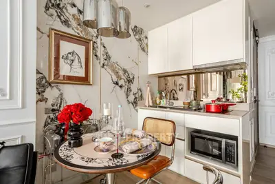 Chic modern kitchen with marble accents and stylish dining area, perfect for urban living.