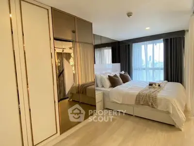 Luxurious bedroom with mirrored wardrobe and large window view