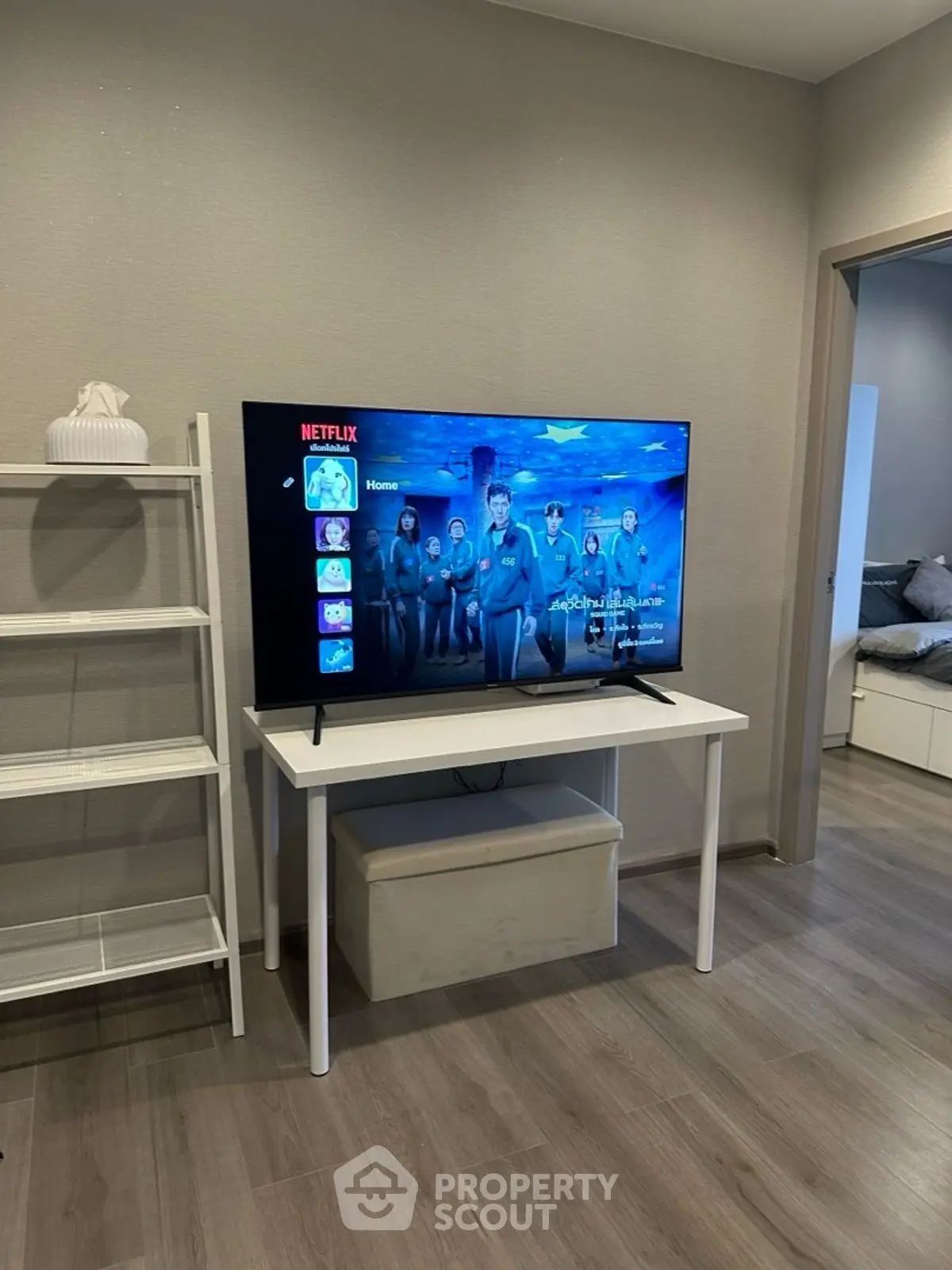Modern living room with sleek TV setup and stylish shelving unit, perfect for entertainment and relaxation.