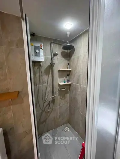 Modern bathroom with sleek shower and tiled walls in a contemporary home.