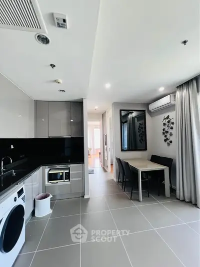 Modern kitchen with sleek appliances and dining area in stylish apartment