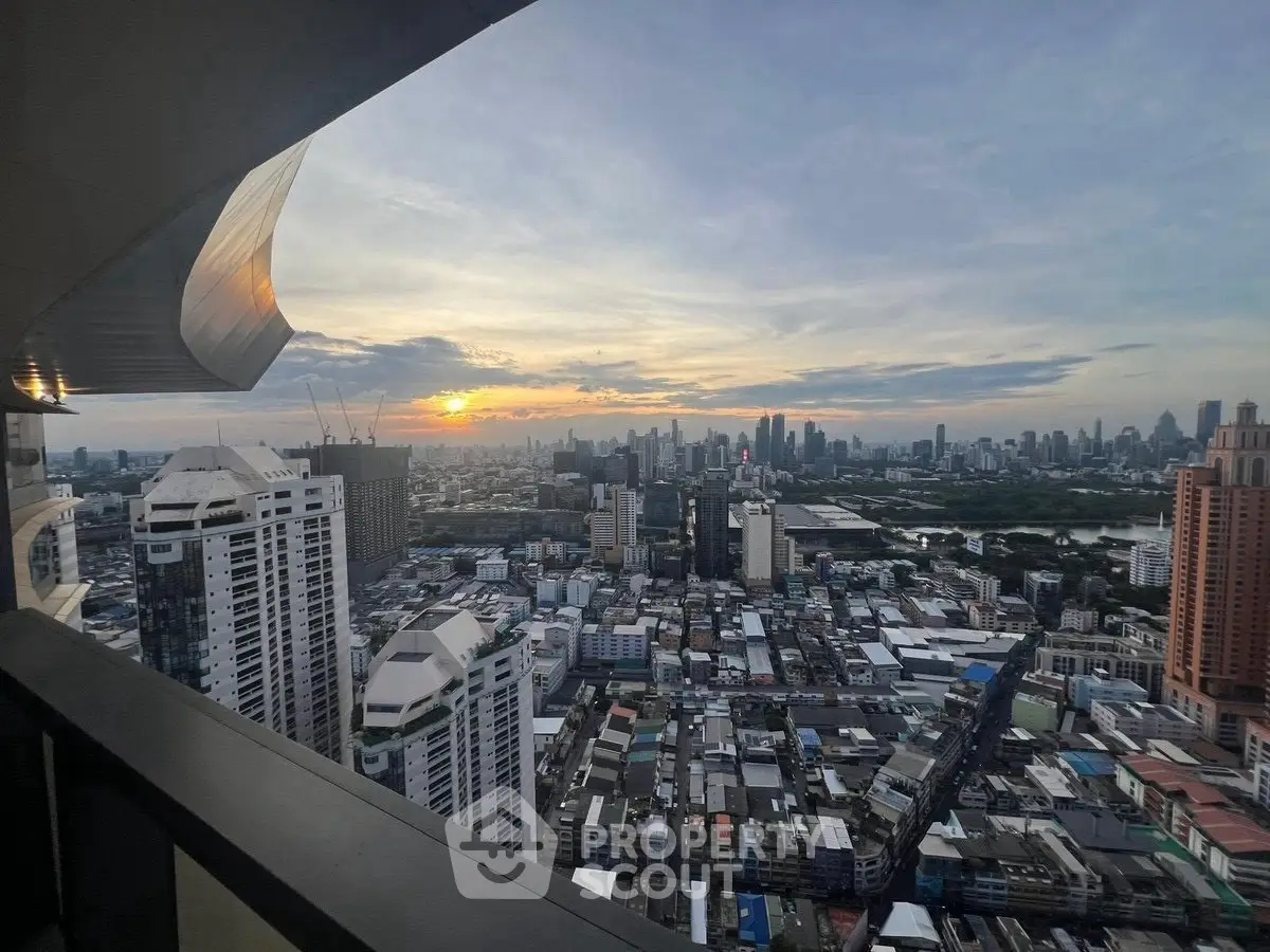 Stunning cityscape view from high-rise balcony at sunset, showcasing urban skyline.