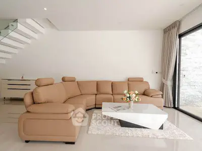 Modern living room with elegant beige sectional sofa and sleek coffee table, perfect for stylish relaxation.