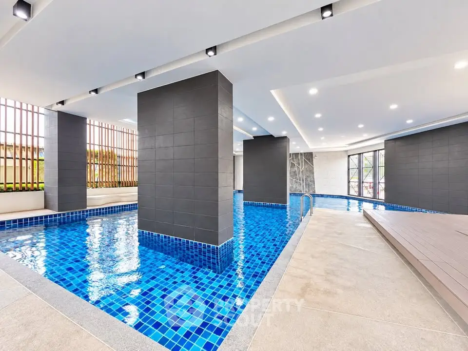 Luxurious indoor swimming pool with modern design and ambient lighting in a high-end residential building.