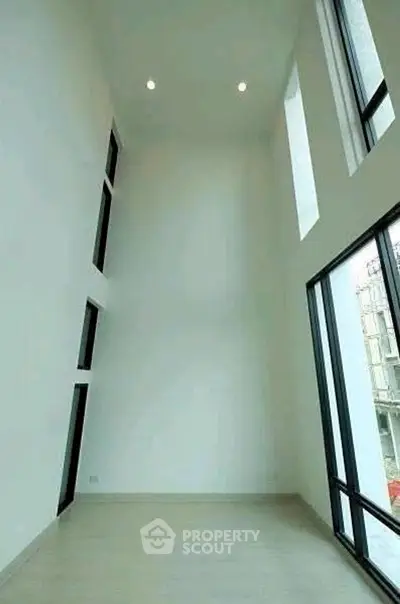 Spacious modern living room with high ceilings and large windows for natural light.