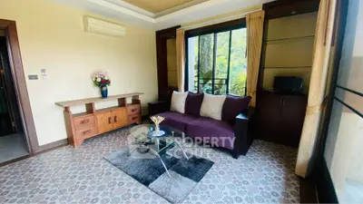 Charming living room with elegant decor, featuring a cozy sofa, stylish coffee table, and large window with lush garden view.