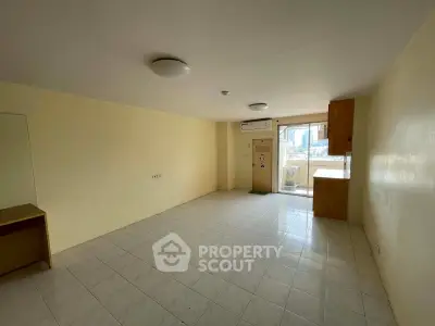 Spacious unfurnished room with tiled flooring and large window offering city views.