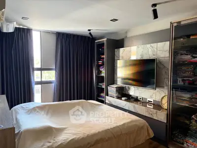 Modern bedroom with sleek design, featuring a wall-mounted TV and ample natural light.