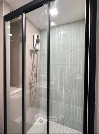 Modern bathroom with sleek glass shower enclosure and contemporary tile design.
