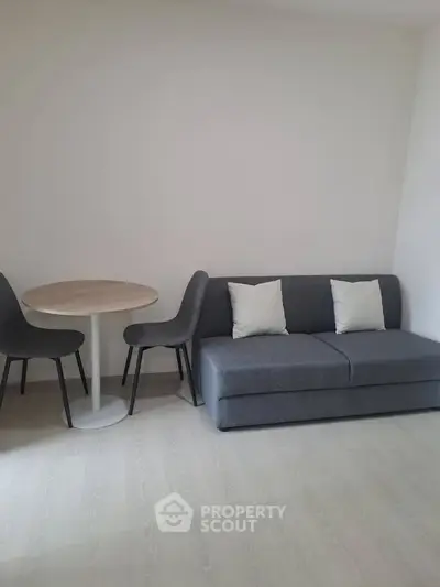 Modern minimalist living room with gray sofa and round dining table