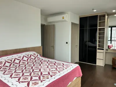 Spacious bedroom with modern design, featuring a large bed, built-in wardrobe, and air conditioning.
