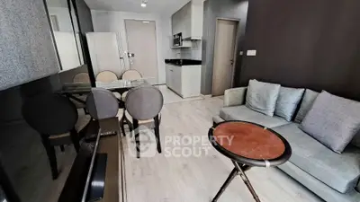 Modern living room with open kitchen, stylish furniture, and sleek design in a contemporary apartment.