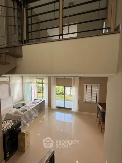 Spacious modern living room with high ceiling and large windows