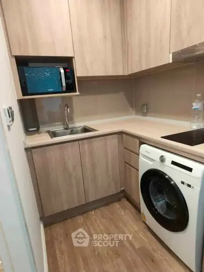 Modern compact kitchen with wooden cabinets and built-in appliances