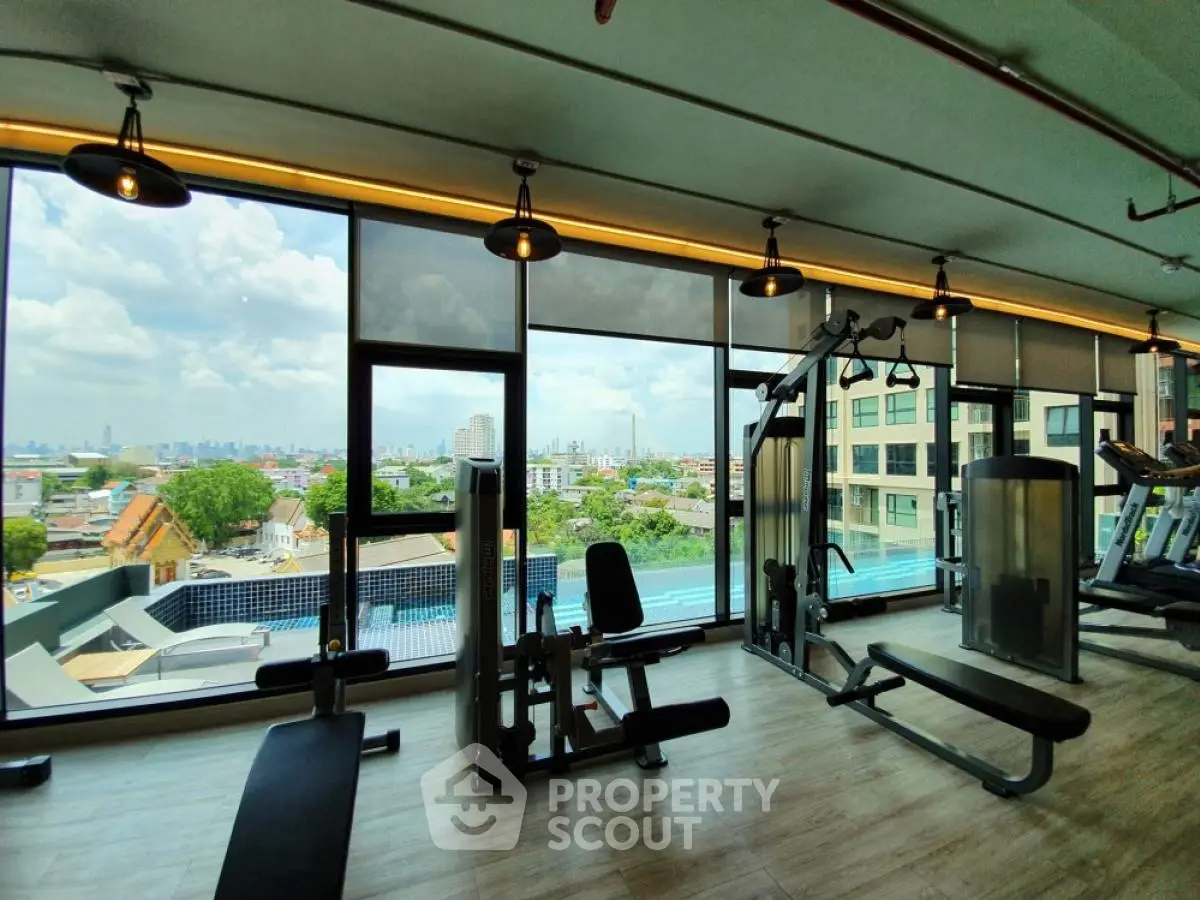 Modern gym with panoramic city view and state-of-the-art fitness equipment.