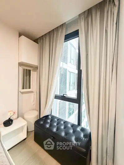 Cozy bedroom corner with window view and stylish storage bench