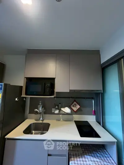 Modern compact kitchen with sleek cabinetry and built-in appliances