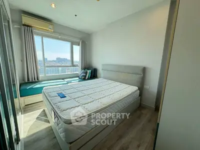 Bright bedroom with large window and city view, featuring a comfortable bed and modern decor.
