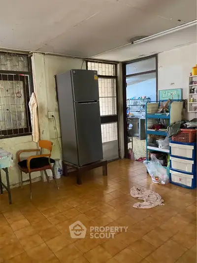 Spacious kitchen with fridge and storage in a cozy home setting.