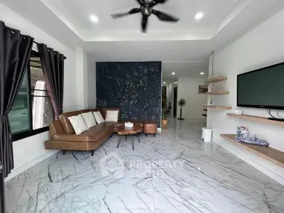 Modern living room with marble flooring, brown leather sofa, and wall-mounted TV.