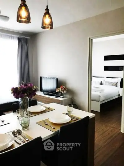 Modern dining area with elegant table setting and view into cozy bedroom
