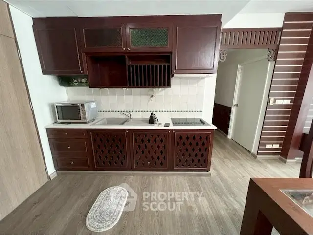 Charming kitchen with wooden cabinets and modern appliances in cozy apartment.