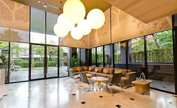 Luxurious modern lobby with elegant seating and large windows overlooking lush garden.