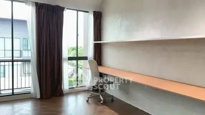 Bright study room with large window and modern desk in a contemporary apartment.