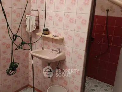 Vintage bathroom with floral tiles and wall-mounted sink