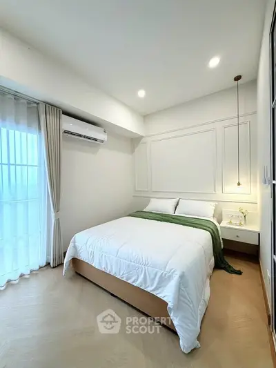 Modern bedroom with elegant decor and natural light, featuring a cozy bed and stylish lighting.