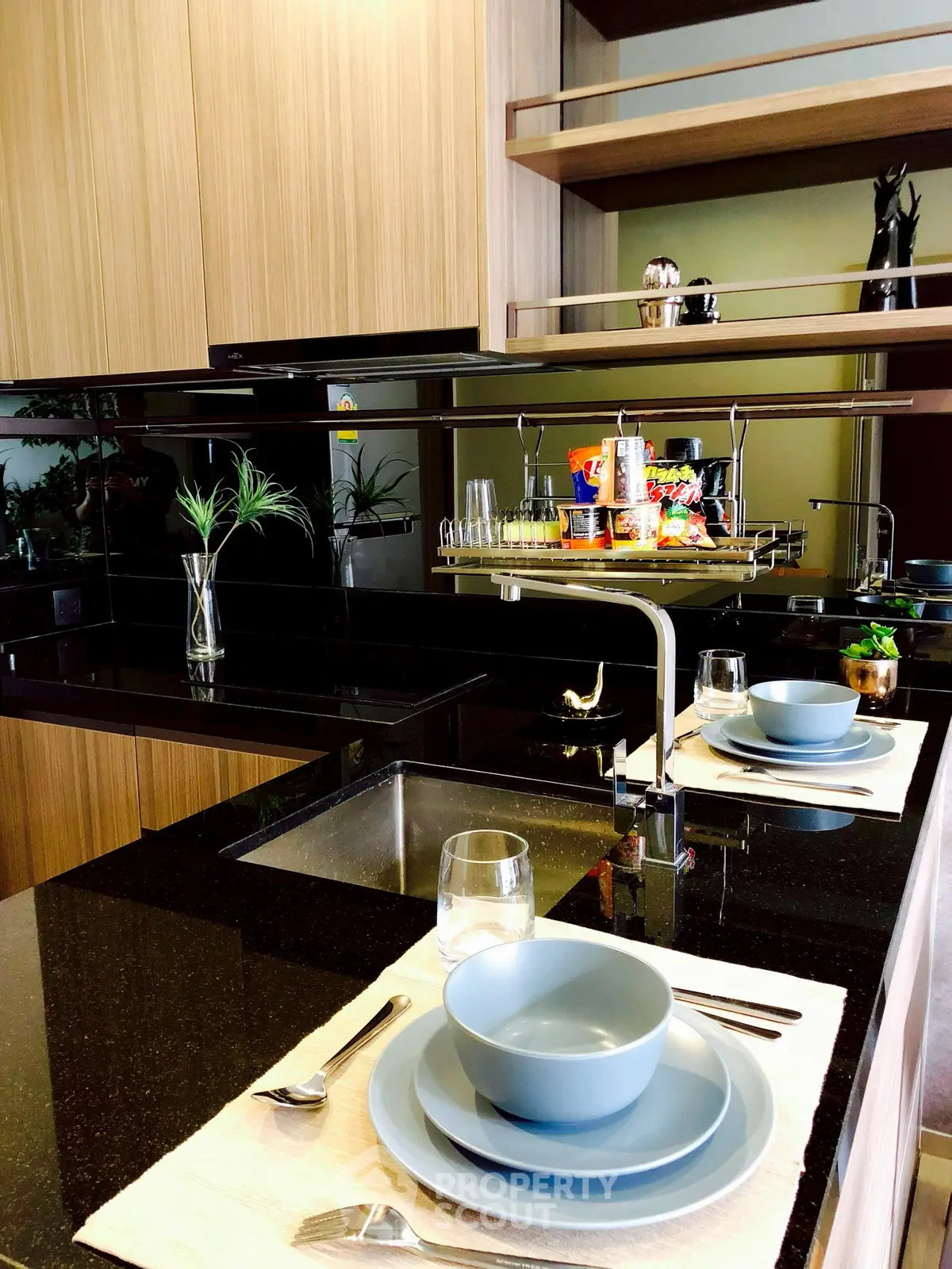 Modern kitchen with sleek black countertops and elegant table setting