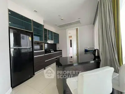 Modern kitchen with sleek cabinetry and black appliances in a bright, spacious apartment.