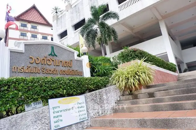 Elegant resort entrance with lush greenery and traditional architectural elements.