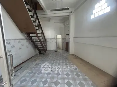 Spacious interior with high ceiling and staircase, ideal for creative renovation.