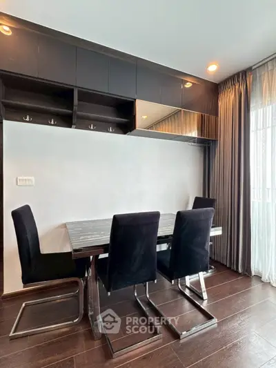 Modern dining area with sleek black chairs and elegant table in a stylish apartment.